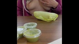 Mulher sexy mostra os peitos em um restaurante enquanto o caixa está no balcão
